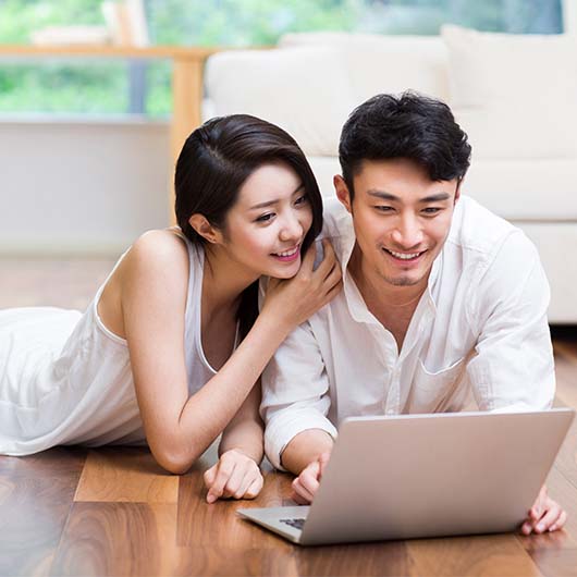 Couple watching something on the laptop on floor